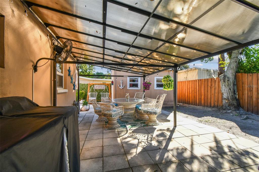 226 Maple Avenue Palm Harbor, FL 34684 - Photo 43 of 79 a view of a patio with table and chairs and wooden fence