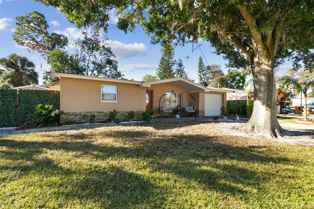 226 Maple Avenue Palm Harbor, FL 34684 - Photo 5 of 79 a front view of a house with a yard and garage