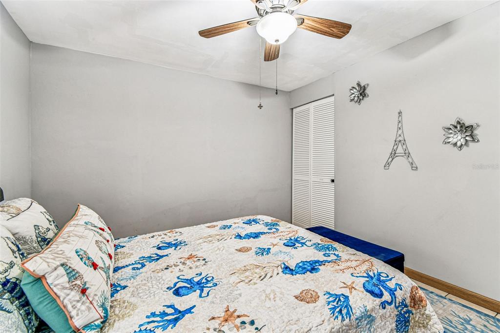 226 Maple Avenue Palm Harbor, FL 34684 - Photo 61 of 79 a bedroom with a bed and a chandelier