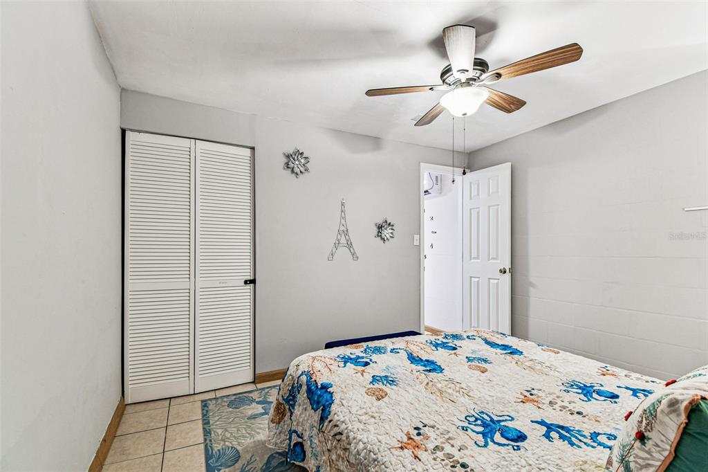 226 Maple Avenue Palm Harbor, FL 34684 - Photo 62 of 79 a bedroom with a bed and a chandelier