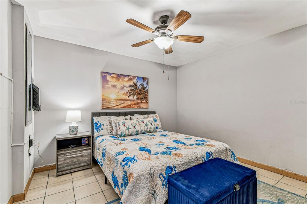226 Maple Avenue Palm Harbor, FL 34684 - Photo 63 of 79 a bedroom with a large bed and a chandelier