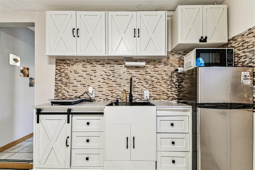 226 Maple Avenue Palm Harbor, FL 34684 - Photo 64 of 79 a kitchen with white cabinets and sink