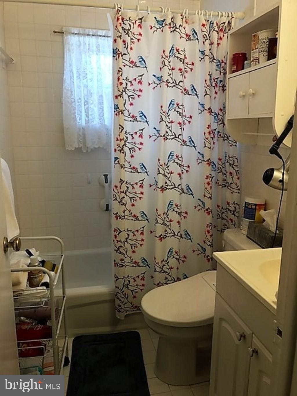 4414 Scotia Road Baltimore, MD 21227 - Photo 14 of 19 a bathroom with a toilet and a shower curtain