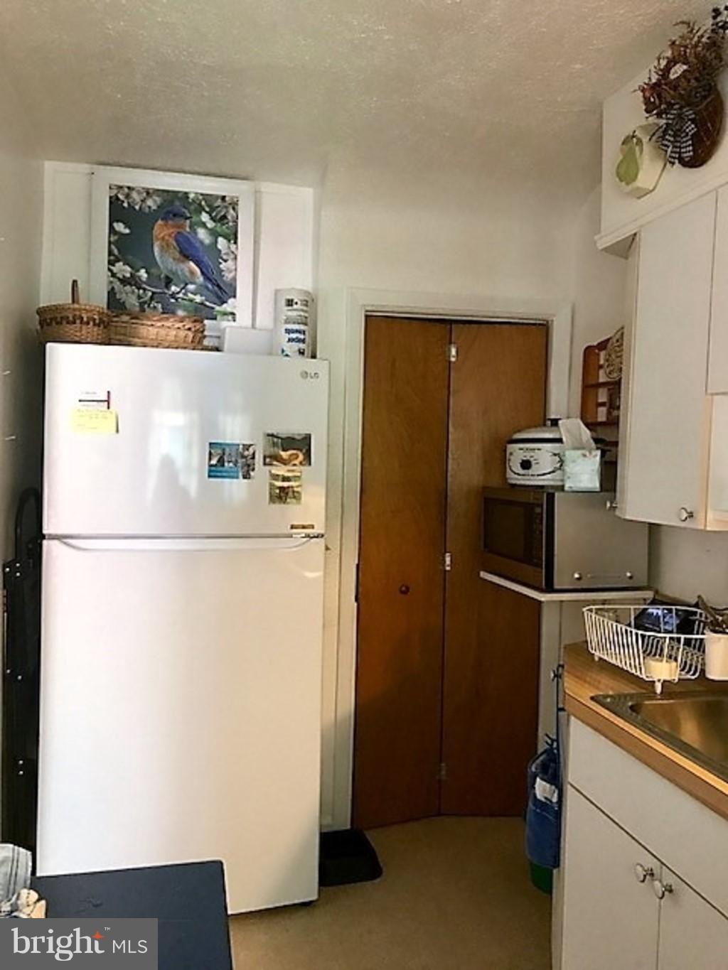 4414 Scotia Road Baltimore, MD 21227 - Photo 7 of 19 a kitchen with a refrigerator and a stove