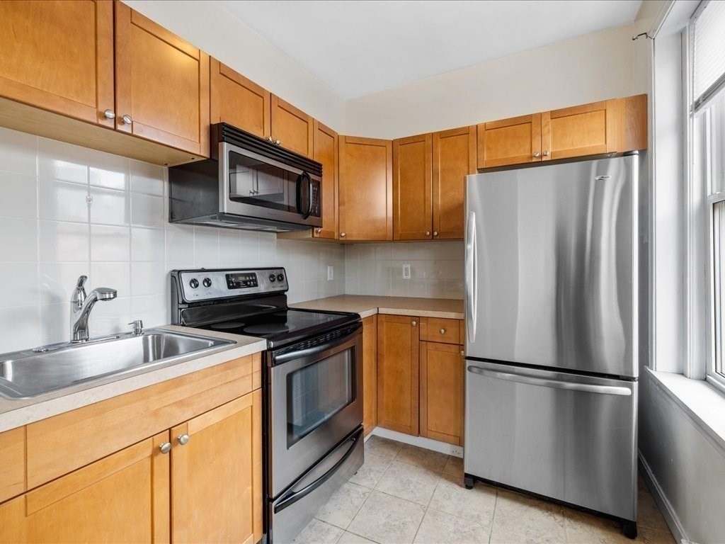 345-347 Hanover Street Boston, MA 02113 - Photo 12 of 22 a kitchen with stainless steel appliances granite countertop a refrigerator stove top oven and sink