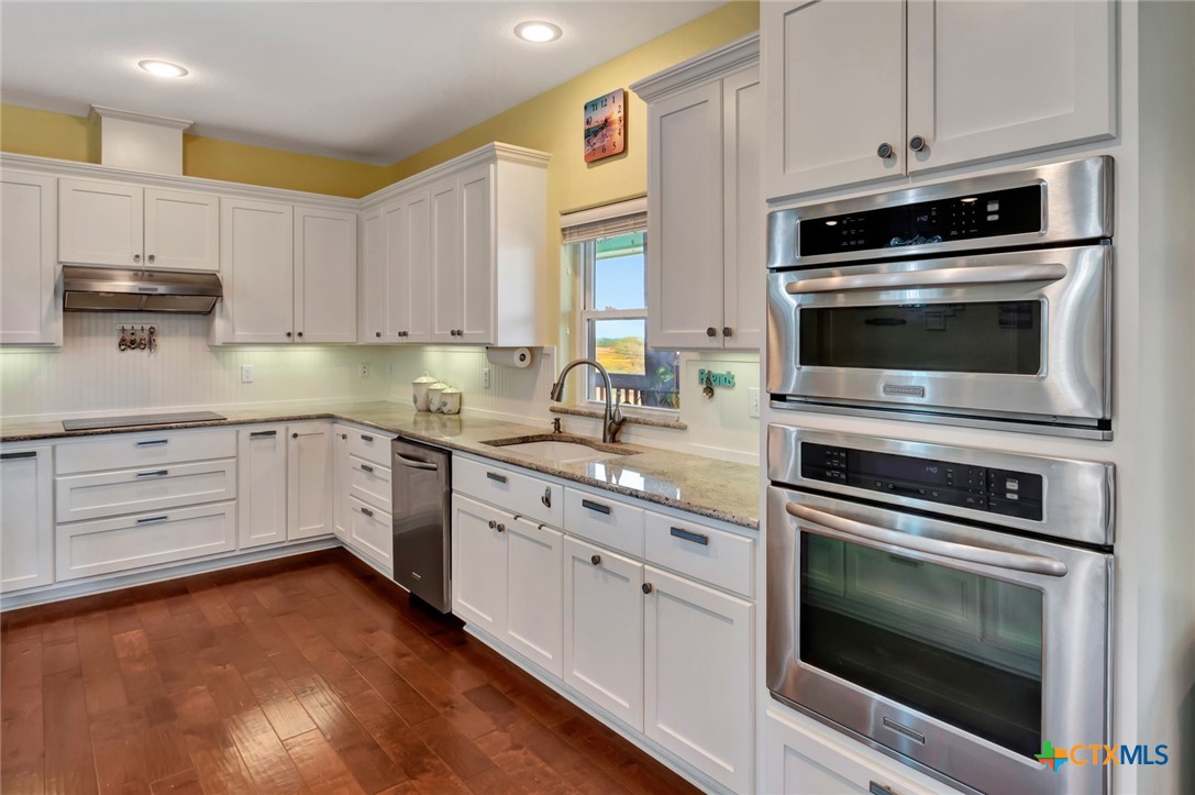 23 Macey Street Port O'Connor, TX 77982 - Photo 14 of 40 a kitchen with granite countertop a stove microwave and sink