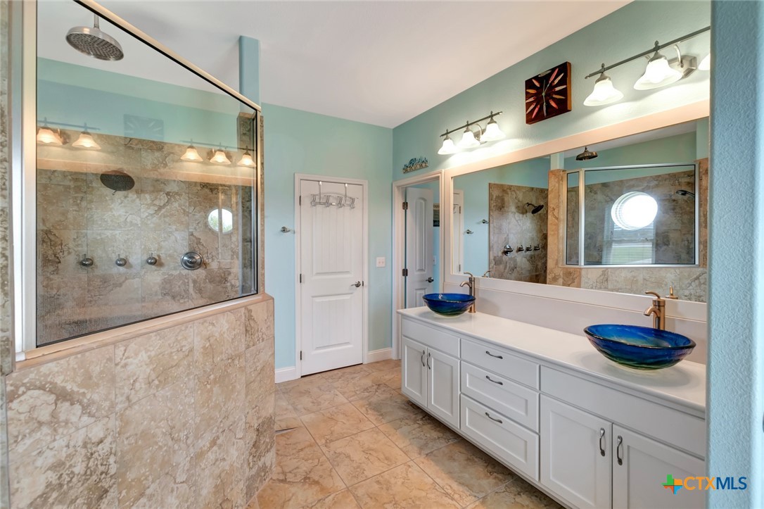 23 Macey Street Port O'Connor, TX 77982 - Photo 23 of 40 a spacious bathroom with a shower sink and mirror