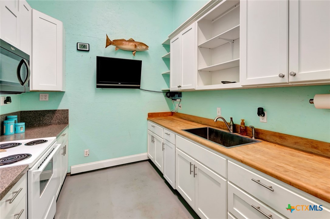 23 Macey Street Port O'Connor, TX 77982 - Photo 37 of 40 a kitchen with stainless steel appliances granite countertop a sink and a microwave