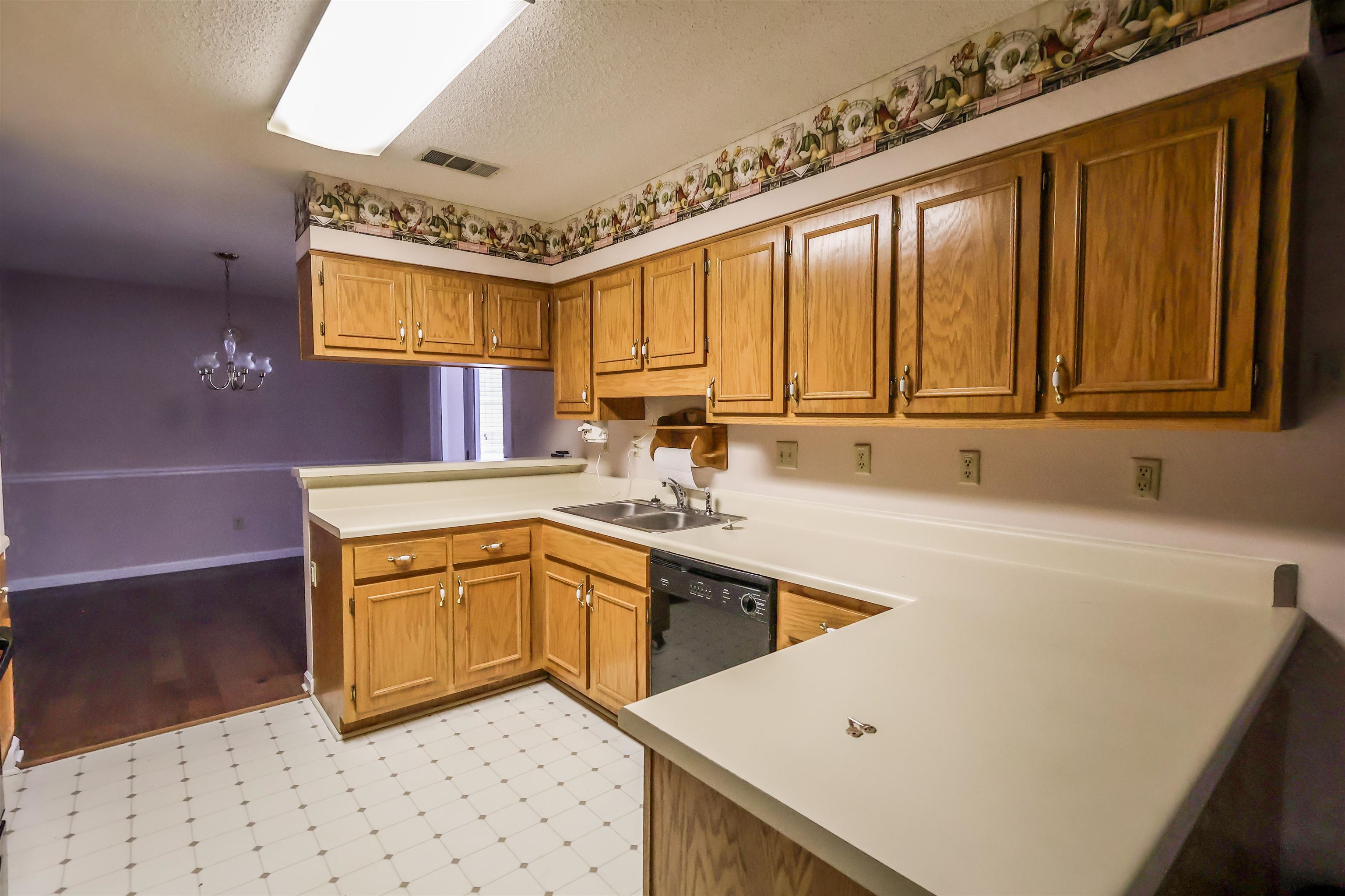 8712 Gragg Road Millington, TN 38053 - Photo 20 of 36 Kitchen featuring a peninsula, wood finish cabinetry, light countertops, light floors, and a textured ceiling