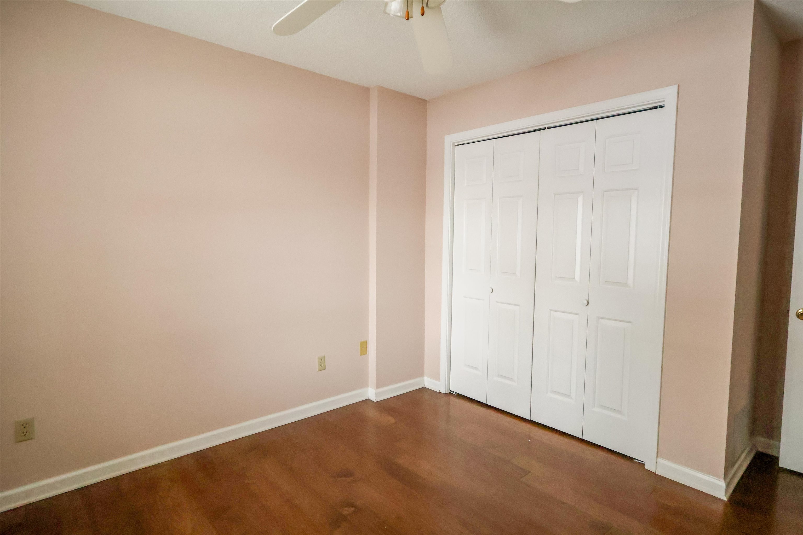 8712 Gragg Road Millington, TN 38053 - Photo 30 of 36 Unfurnished bedroom featuring dark wood-style flooring, a ceiling fan, and a closet