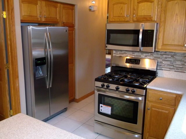 10854 Major Avenue Chicago Ridge, IL 60415 - Photo 6 of 24 a kitchen with stainless steel appliances granite countertop a stove microwave and refrigerator