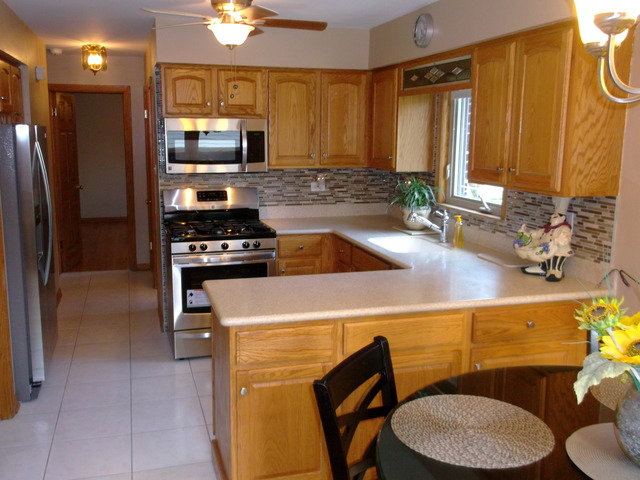 10854 Major Avenue Chicago Ridge, IL 60415 - Photo 8 of 24 a kitchen with stainless steel appliances a sink a stove a chimney a refrigerator and cabinets