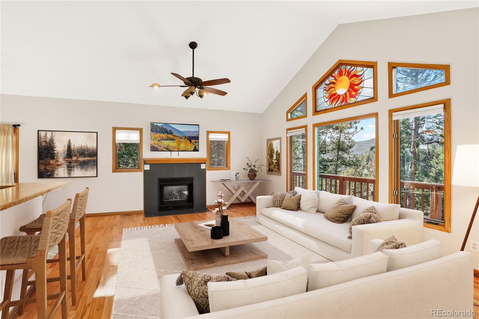 9758 Fallen Rock Road Conifer, CO 80433 - Photo 5 of 42 a living room with furniture a fireplace and a chandelier
