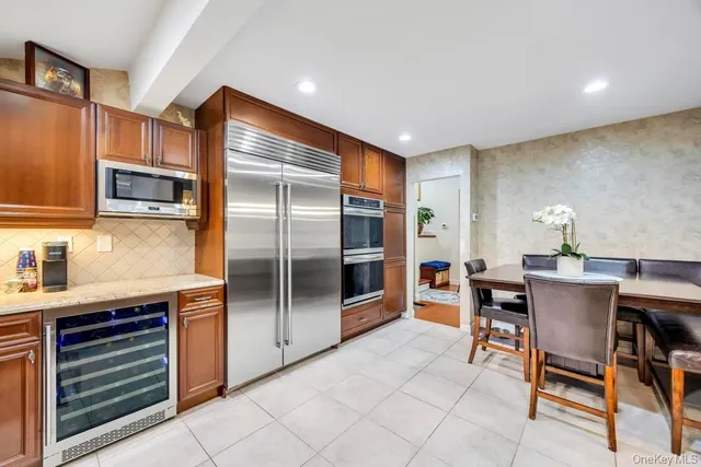 a kitchen with stainless steel appliances kitchen island granite countertop a refrigerator and cabinets