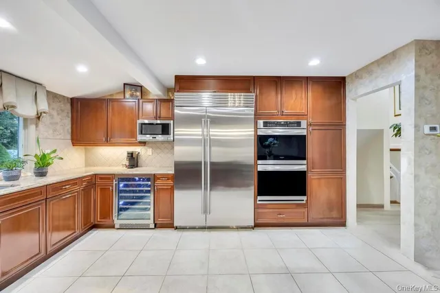 a kitchen with stainless steel appliances granite countertop a refrigerator and a sink