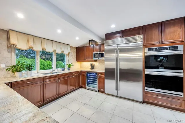 a kitchen with stainless steel appliances granite countertop a refrigerator oven a sink and dishwasher