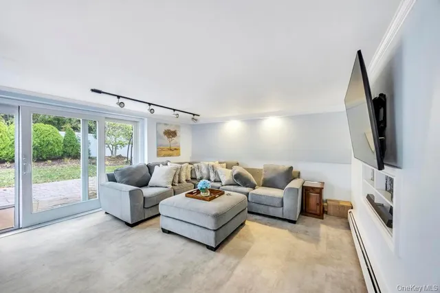 a living room with furniture flat screen tv and a large window