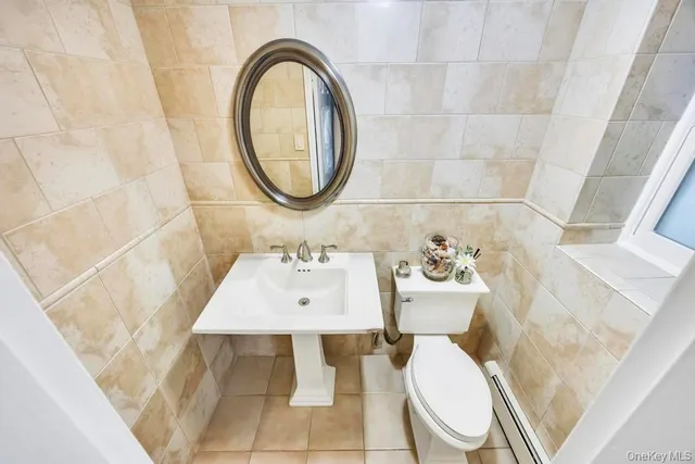 a bathroom with a sink a toilet and a mirror