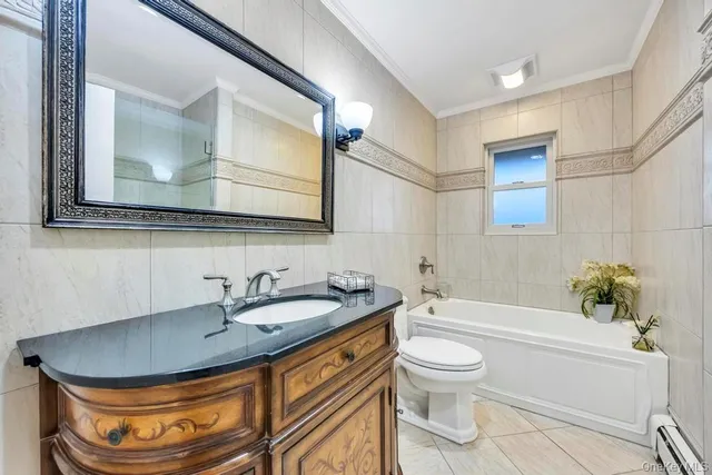 a bathroom with a granite countertop sink a toilet a mirror and bathtub