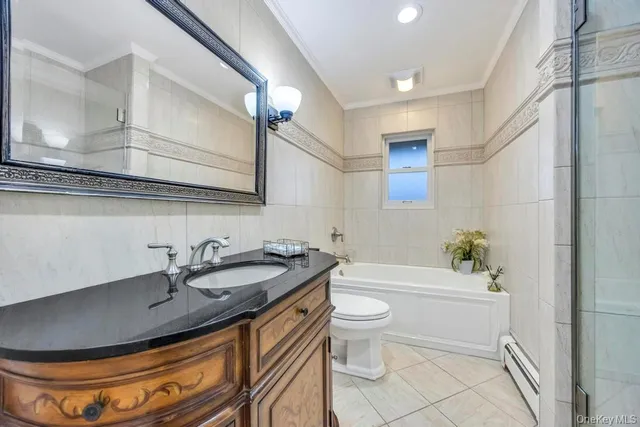 a bathroom with a granite countertop sink a toilet a mirror and bathtub