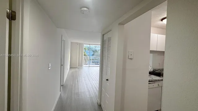 a view of a hallway with wooden floor and a cabinet