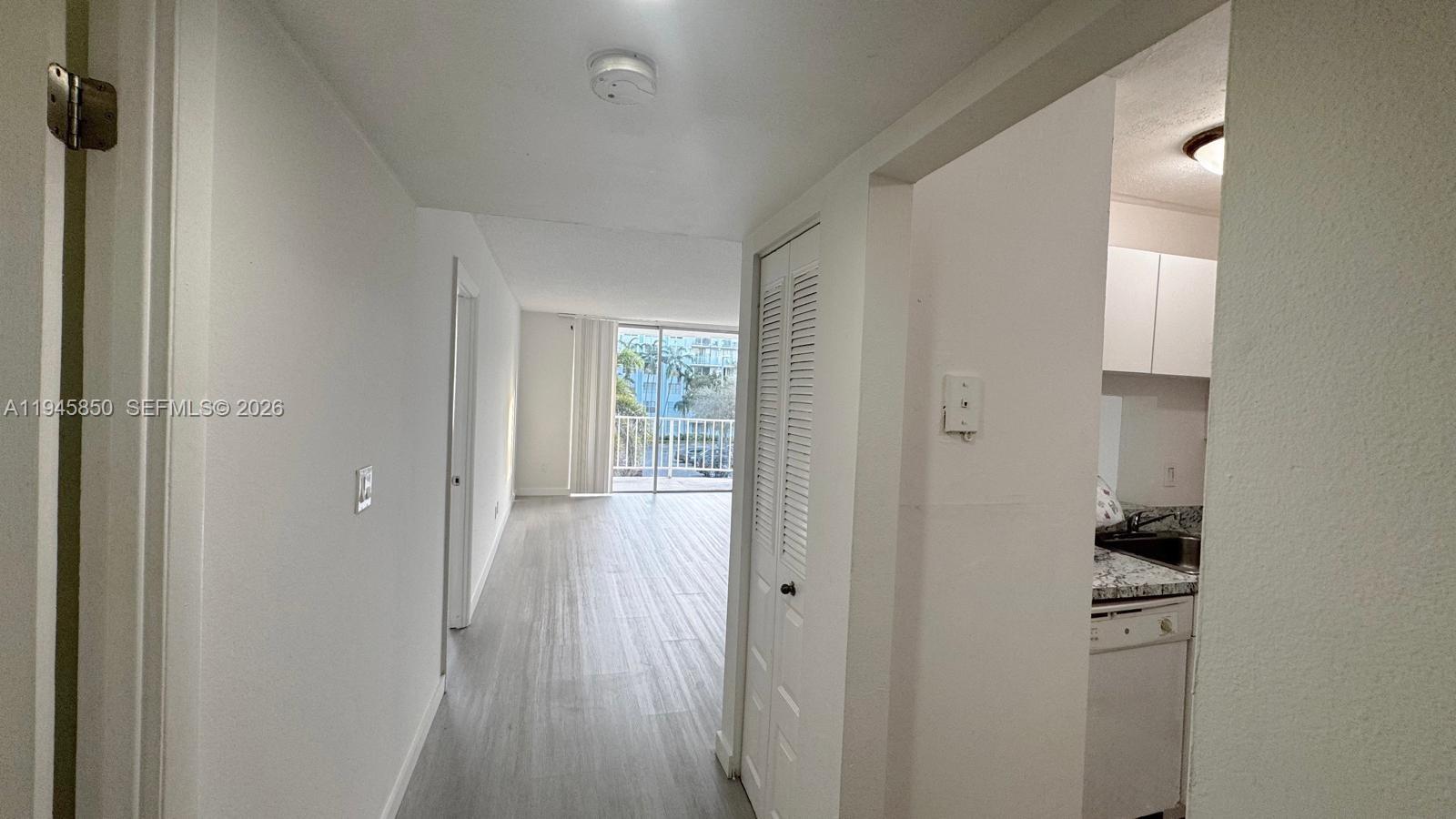 484 Northwest 165th St Road, Unit A314 Miami, FL 33169 - Photo 12 of 35 a view of a hallway with wooden floor and a cabinet