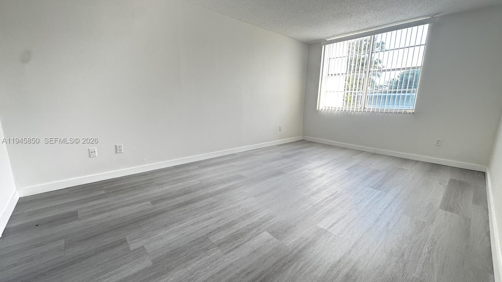 484 Northwest 165th St Road, Unit A314 Miami, FL 33169 - Photo 17 of 35 an empty room with wooden floor and windows