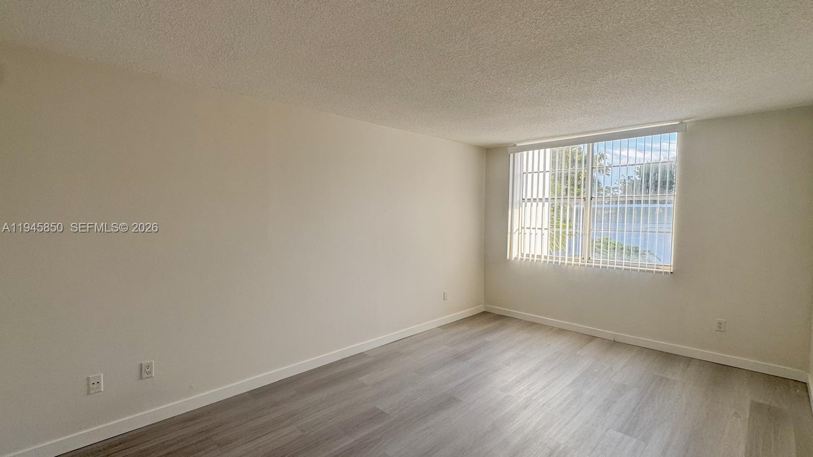 484 Northwest 165th St Road, Unit A314 Miami, FL 33169 - Photo 19 of 35 an empty room with wooden floor and windows