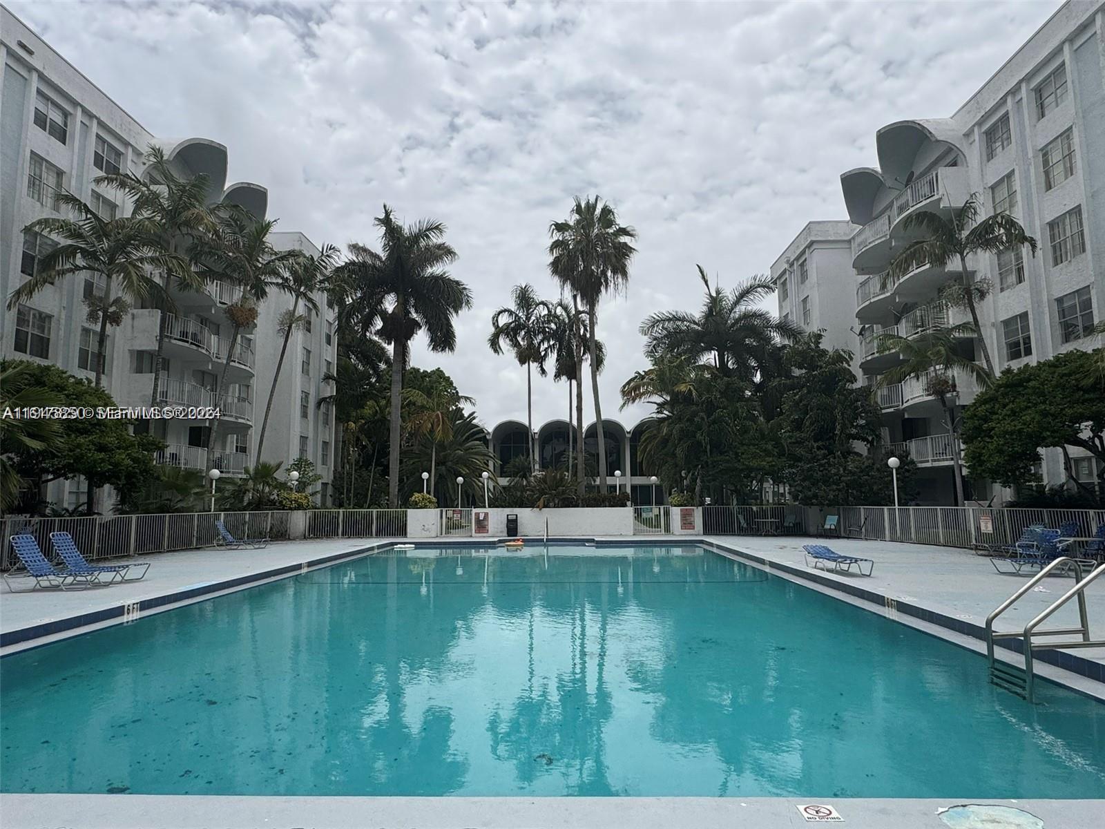 484 Northwest 165th St Road, Unit A314 Miami, FL 33169 - Photo 29 of 35 a swimming pool with outdoor seating and yard