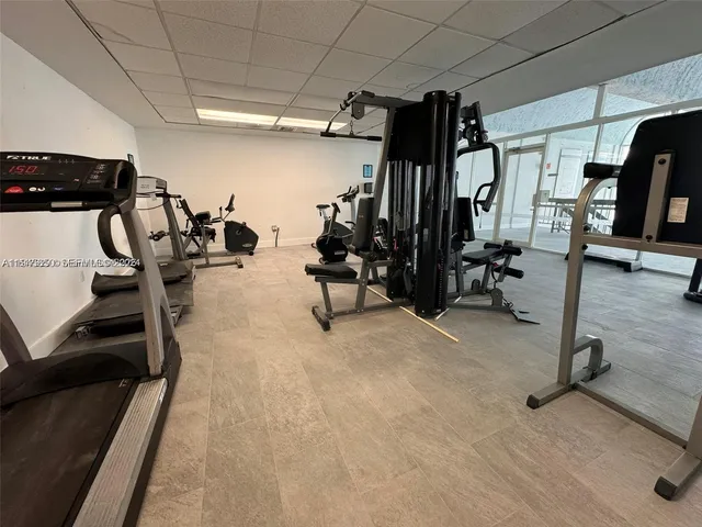 a view of an empty room with wooden floor and windows