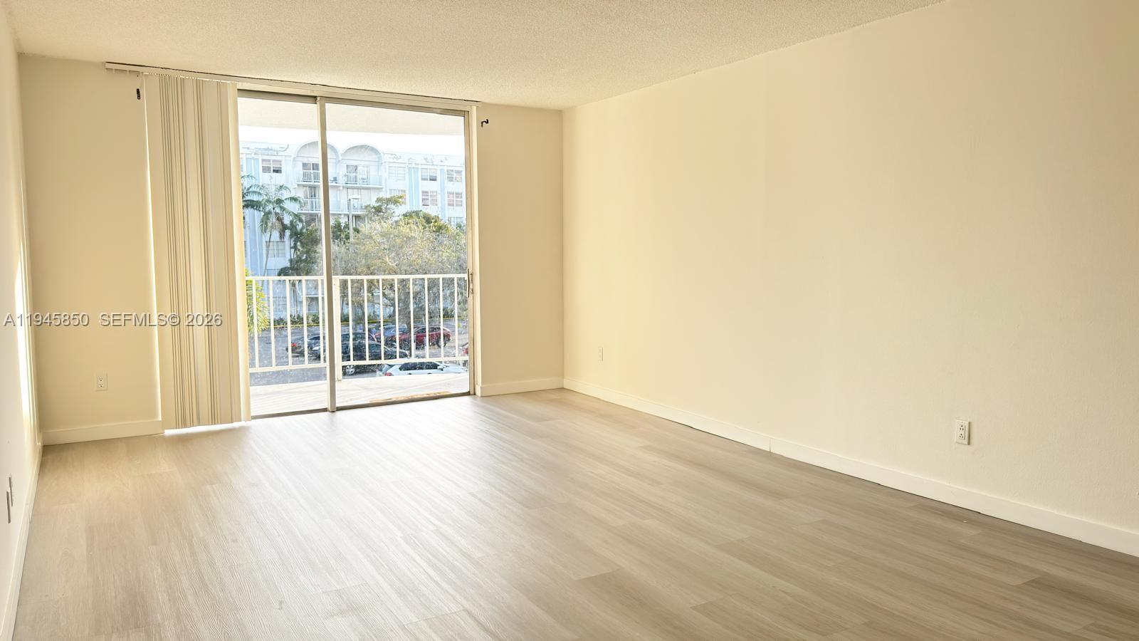 484 Northwest 165th St Road, Unit A314 Miami, FL 33169 - Photo 7 of 35 a view of wooden floor and windows in a room