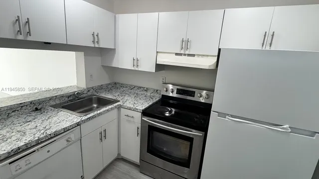 a kitchen with granite countertop white cabinets and black appliances