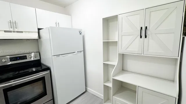 a kitchen with white cabinets and white appliances