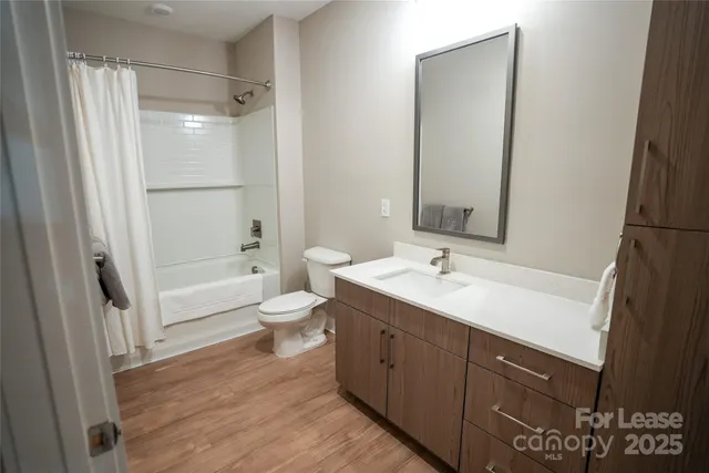 a bathroom with a granite countertop sink toilet a mirror and shower