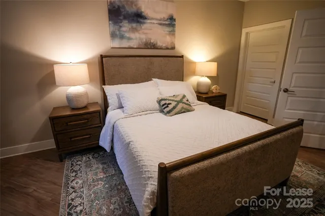 a bedroom with a bed and lamps with wooden floor