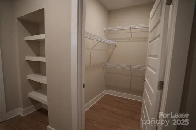 a view of walk in closet with empty racks