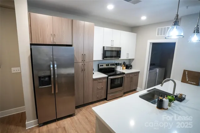 a kitchen with stainless steel appliances a refrigerator microwave and stove top oven