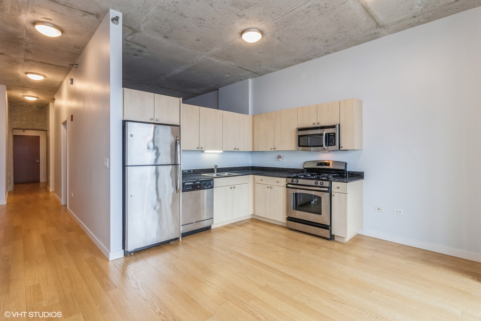 235 West Van Buren Street, Unit 4209 Chicago, IL 60607 - Photo 5 of 10 a kitchen with white cabinets and stainless steel appliances