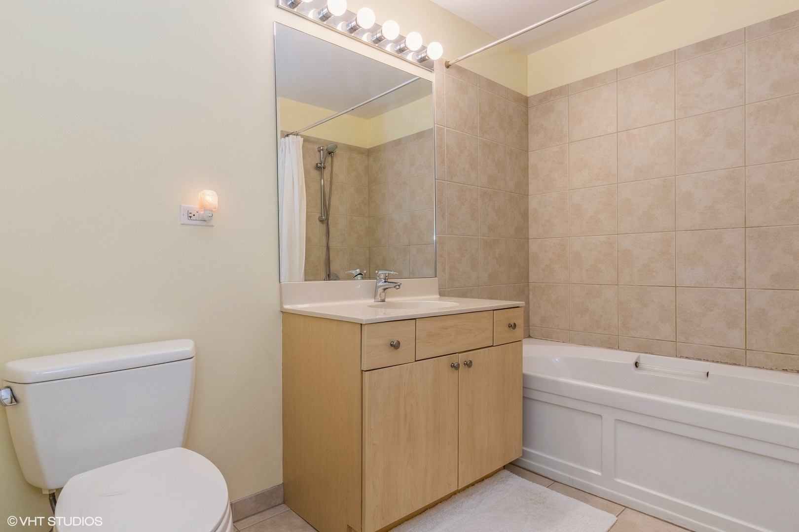 235 West Van Buren Street, Unit 4209 Chicago, IL 60607 - Photo 9 of 10 a bathroom with a sink a toilet and shower