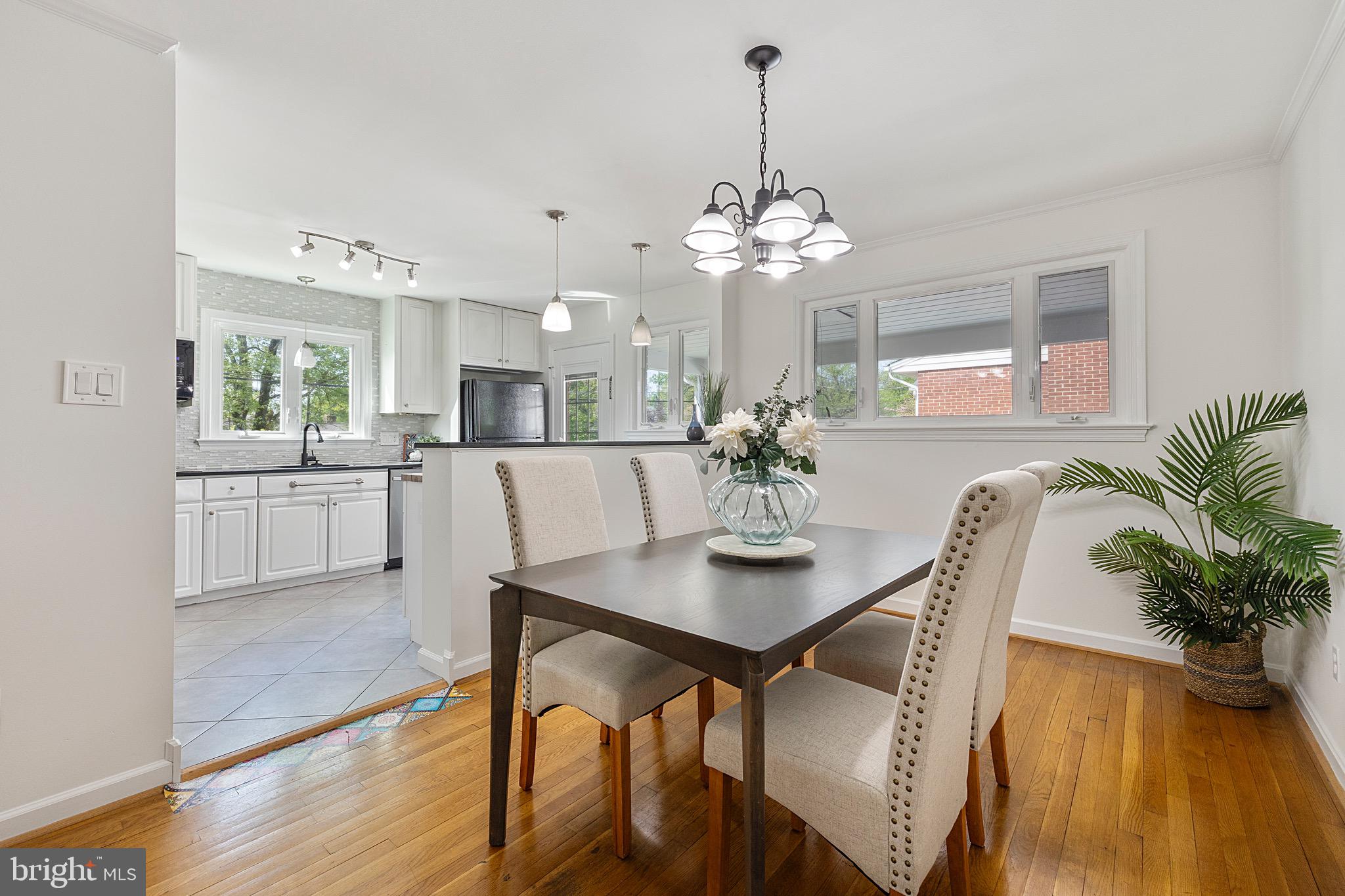 9821 Singleton Drive Bethesda, MD 20817 - Photo 6 of 45 a view of a dining room with furniture a chandelier and wooden floor