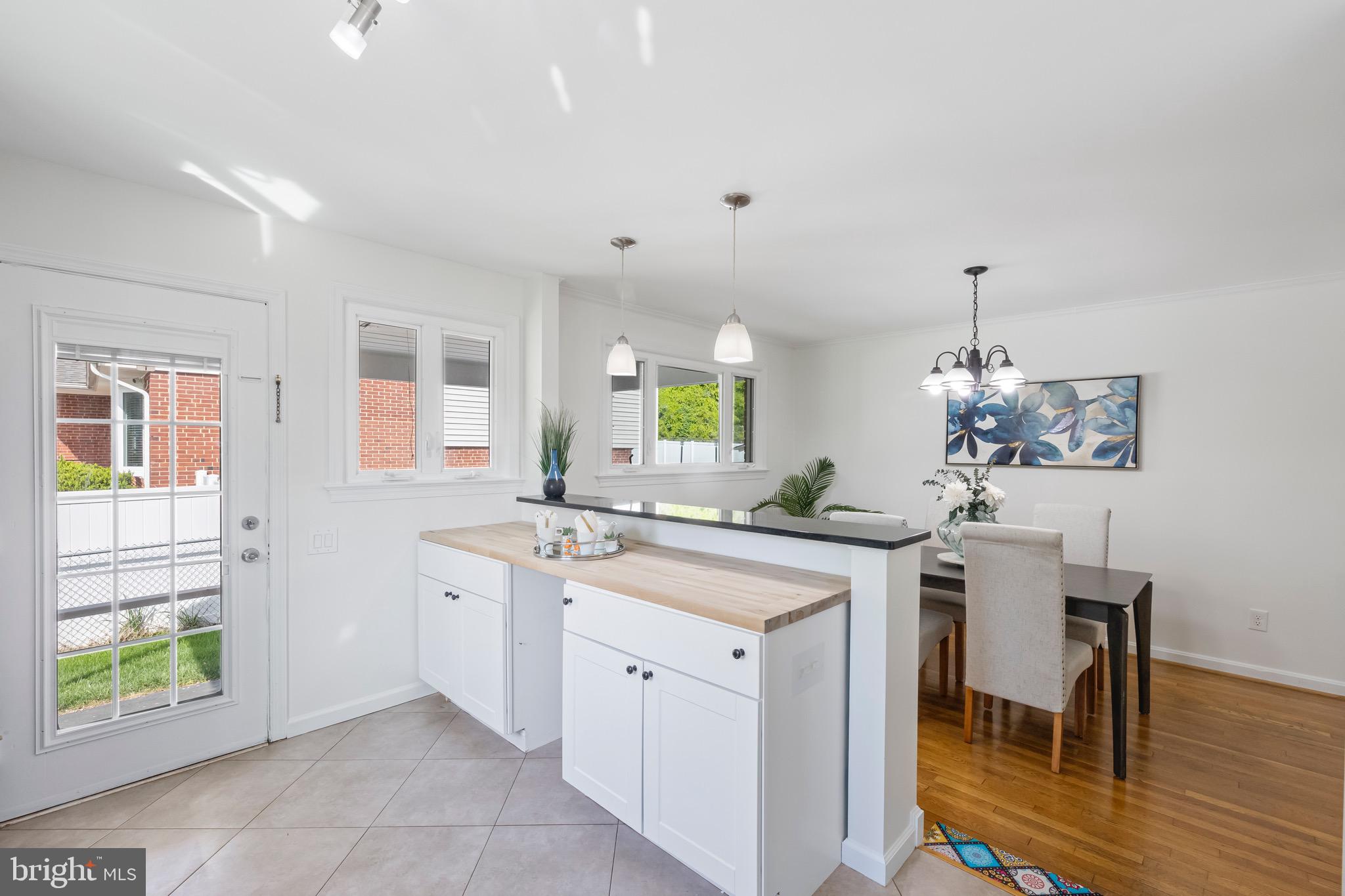9821 Singleton Drive Bethesda, MD 20817 - Photo 9 of 45 a kitchen with a stove a sink a dining table and chairs