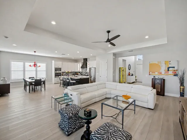 a kitchen with stainless steel appliances kitchen island granite countertop a table chairs stove and refrigerator