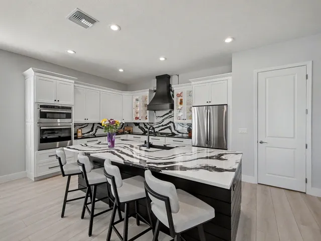 a kitchen with stainless steel appliances kitchen island granite countertop a sink and cabinets
