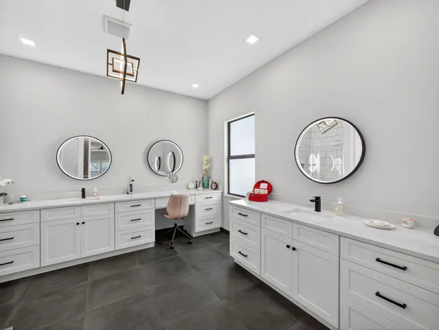 a spacious bathroom with a granite countertop sink a mirror and a vanity
