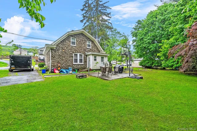 a front view of a house with garden and trees