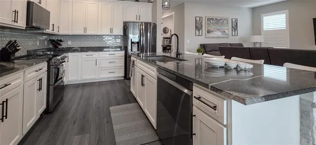 a kitchen with appliances a refrigerator and cabinets