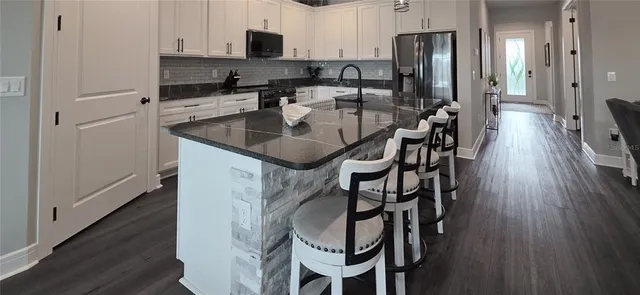 a kitchen with granite countertop white cabinets and a stove