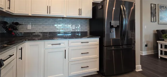 a kitchen with stainless steel appliances kitchen island granite countertop a stove a refrigerator a kitchen island a dining table and chairs