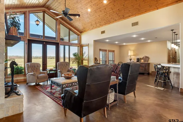 a living room with furniture kitchen view and large windows