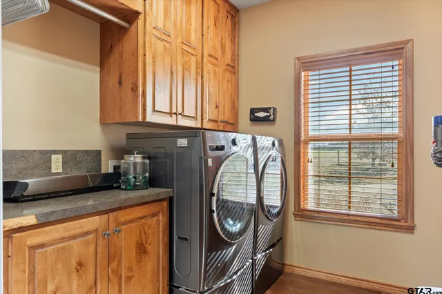 a utility room with stainless steel appliances granite countertop a sink and a window